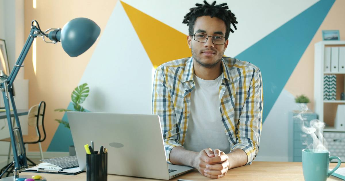 A self-employed person working at a laptop in a home office